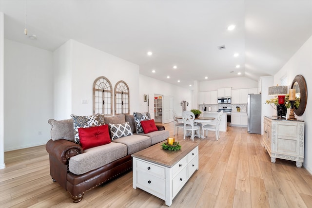 living room with lofted ceiling and light wood-type flooring