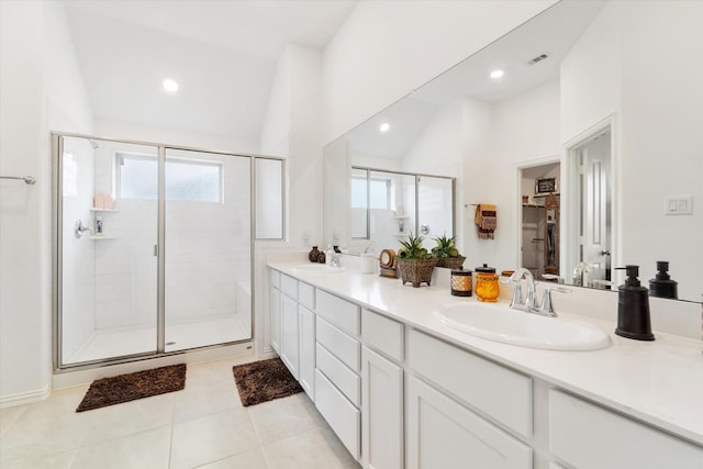 bathroom featuring tile patterned flooring, vanity, walk in shower, and vaulted ceiling