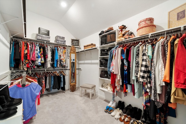 walk in closet with carpet flooring and vaulted ceiling