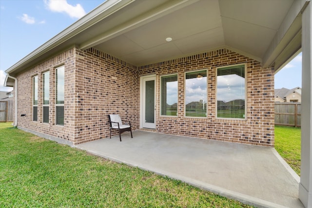 entrance to property featuring a yard and a patio