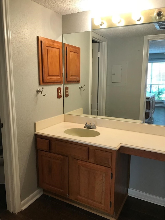 bathroom with a textured ceiling and vanity