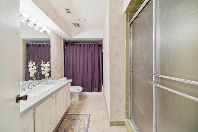 bathroom featuring tile patterned flooring, vanity, toilet, and an enclosed shower