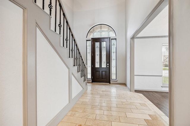 foyer featuring a towering ceiling and light hardwood / wood-style flooring