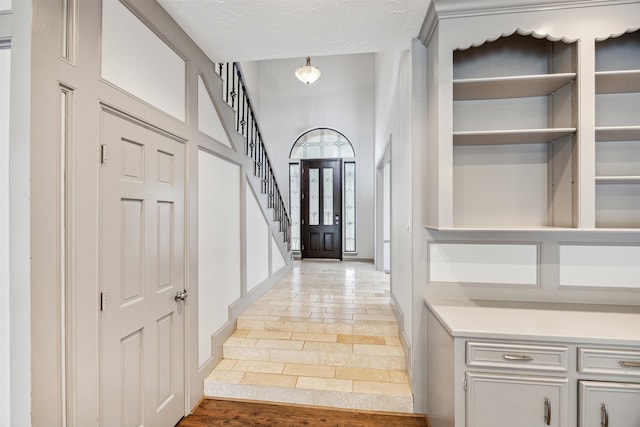 entryway with hardwood / wood-style floors and a textured ceiling