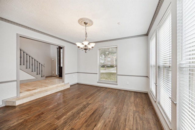 unfurnished dining area with a chandelier, ornamental molding, and hardwood / wood-style flooring