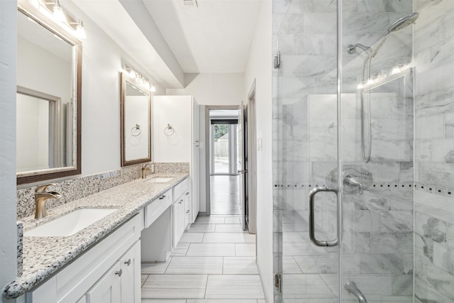 bathroom featuring tile patterned floors, a shower with door, and vanity