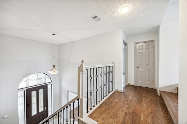 corridor featuring dark hardwood / wood-style flooring and a textured ceiling