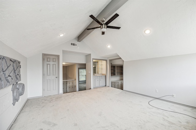 unfurnished living room featuring ceiling fan, carpet, and lofted ceiling with beams