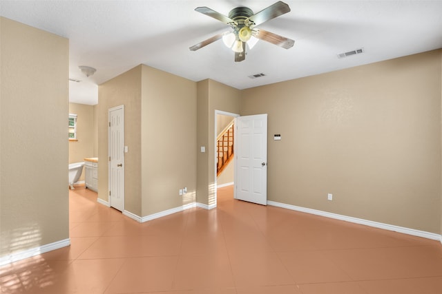 spare room with ceiling fan and light tile patterned floors