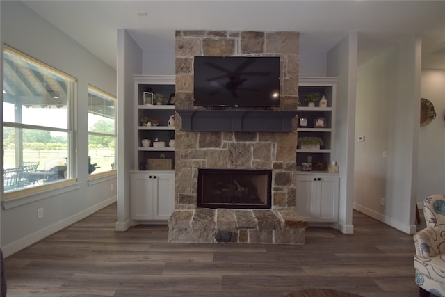 living room featuring hardwood / wood-style floors, built in features, and a fireplace