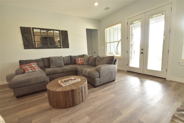 living room with french doors and light wood-type flooring