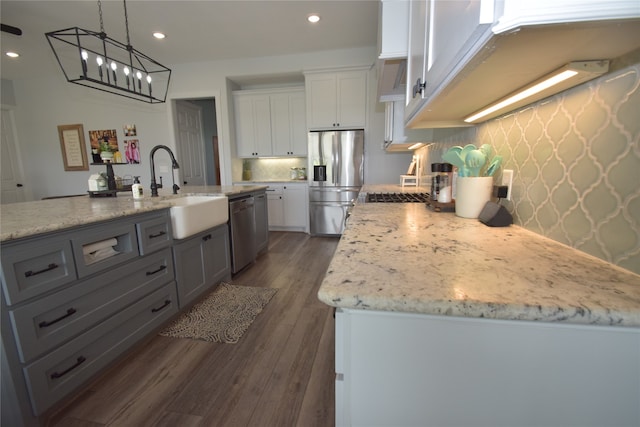 kitchen featuring white cabinetry, sink, dark hardwood / wood-style floors, a kitchen island with sink, and appliances with stainless steel finishes