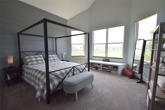 bedroom featuring carpet, high vaulted ceiling, and wooden walls