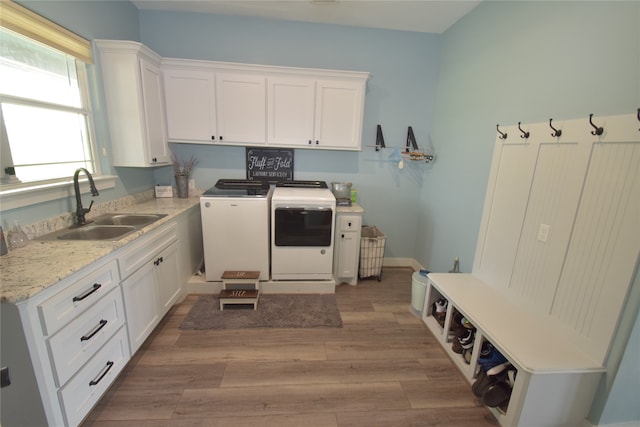 washroom featuring cabinets, light wood-type flooring, sink, and washing machine and clothes dryer