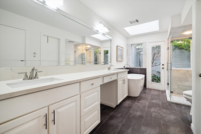 bathroom with vanity, a skylight, and independent shower and bath