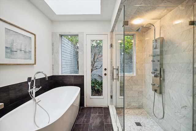 bathroom featuring independent shower and bath and a skylight