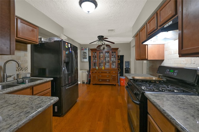 kitchen featuring black appliances, a textured ceiling, sink, and dark wood-type flooring