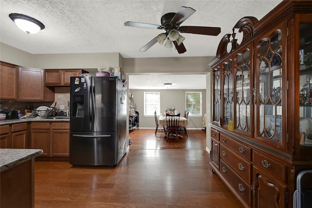 kitchen with a textured ceiling, dark hardwood / wood-style flooring, and stainless steel refrigerator with ice dispenser