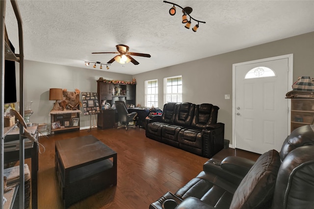 living room with dark hardwood / wood-style floors, ceiling fan, and a textured ceiling