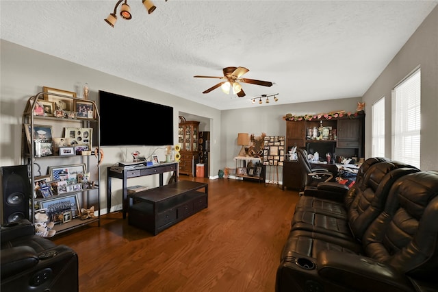 living room featuring dark hardwood / wood-style floors, ceiling fan, and a textured ceiling