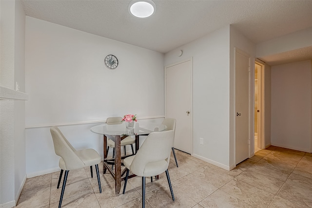 dining space with a textured ceiling