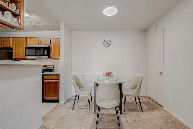 tiled dining space featuring a textured ceiling