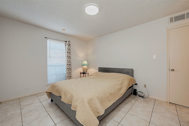 tiled bedroom featuring a textured ceiling