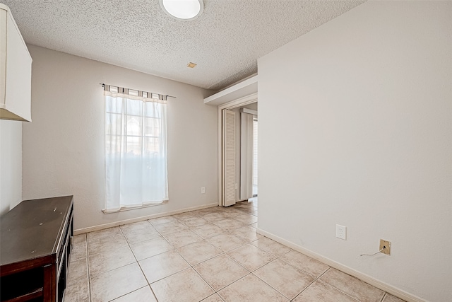 interior space with light tile patterned floors and a textured ceiling