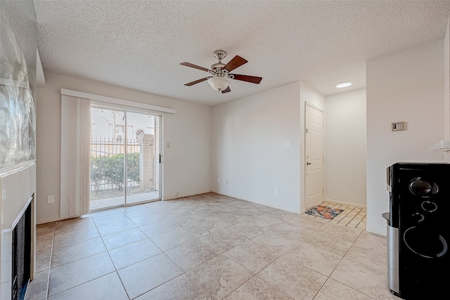 unfurnished living room with light tile patterned floors, a textured ceiling, and ceiling fan