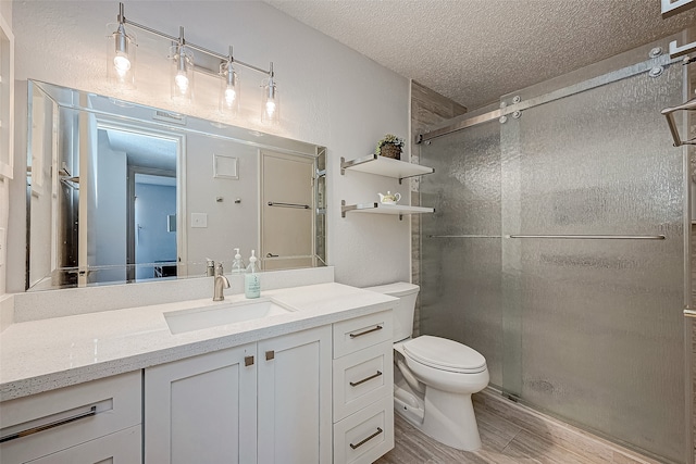 bathroom featuring vanity, hardwood / wood-style floors, a textured ceiling, and a shower with door