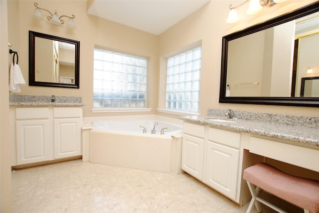 bathroom featuring tile patterned flooring, vanity, and a tub to relax in