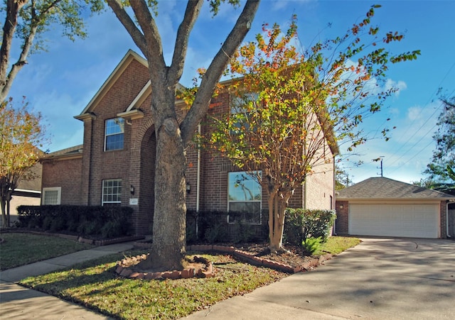 view of front of home with an outbuilding, brick siding, and a garage