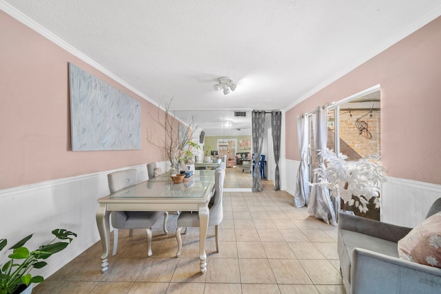 tiled dining room featuring a textured ceiling and ornamental molding