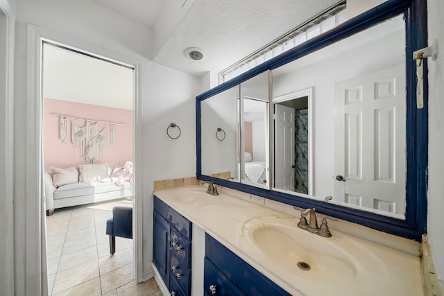 bathroom featuring tile patterned flooring, vanity, and a textured ceiling