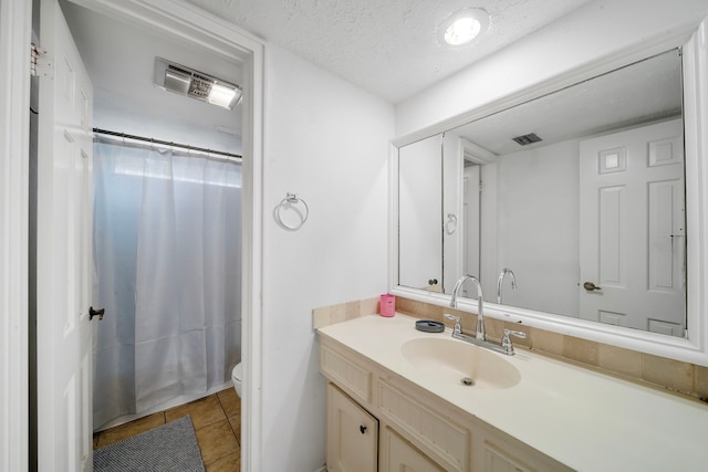 full bathroom with shower / bath combination with curtain, tile patterned floors, vanity, a textured ceiling, and toilet