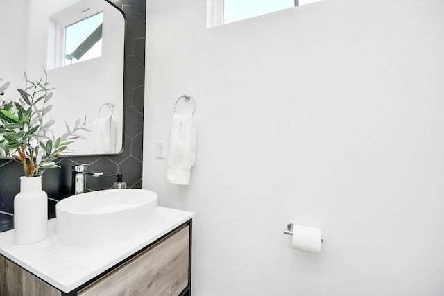 bathroom with vanity, a wealth of natural light, and tasteful backsplash