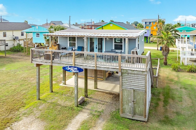 rear view of house with a wooden deck and a lawn