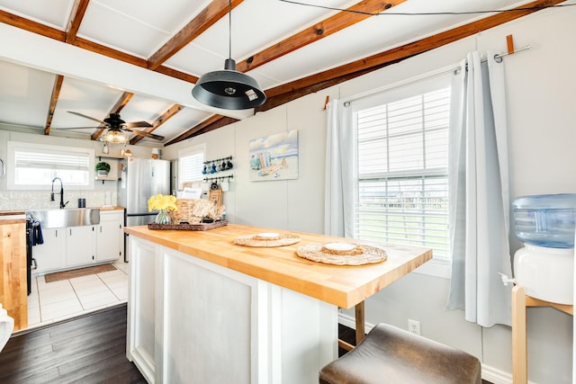 kitchen with white cabinets, wooden counters, dark wood-type flooring, stainless steel fridge, and ceiling fan