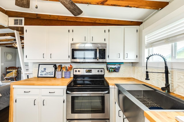 kitchen with appliances with stainless steel finishes, white cabinetry, sink, ceiling fan, and beam ceiling