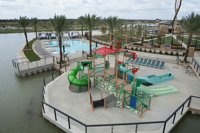 view of pool with a playground and a water view