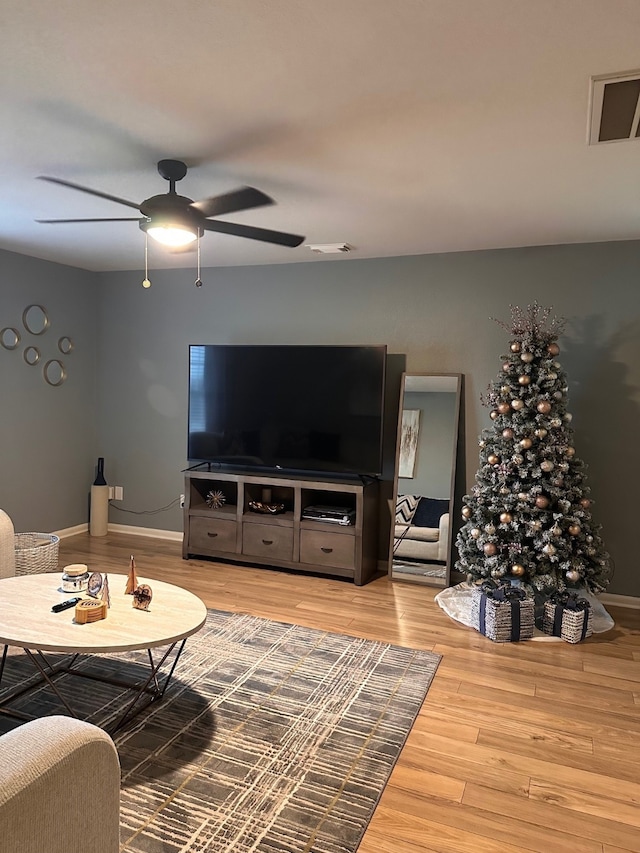 living room with wood-type flooring and ceiling fan