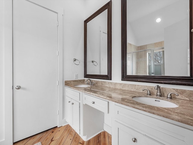 bathroom featuring hardwood / wood-style floors, vanity, and a shower with door