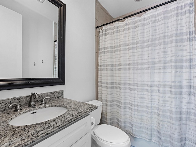 bathroom featuring a shower with curtain, vanity, and toilet