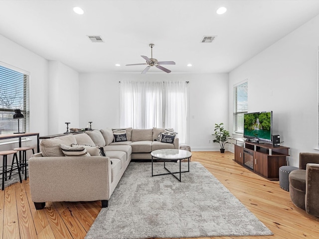 living room featuring light wood-type flooring and ceiling fan