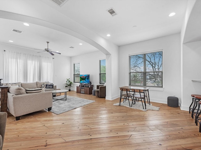 living room with ceiling fan and light hardwood / wood-style flooring