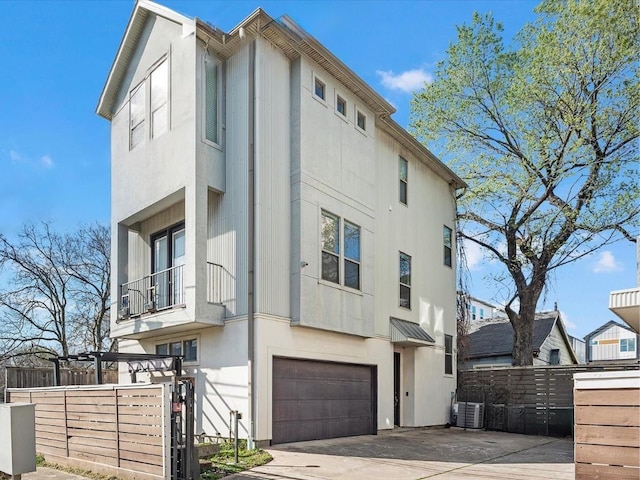 exterior space with central AC, a balcony, and a garage