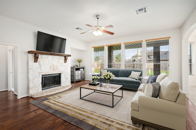 living room with ceiling fan, dark hardwood / wood-style flooring, and a fireplace