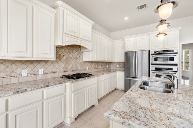 kitchen featuring decorative backsplash, stainless steel appliances, white cabinets, and sink