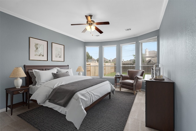 carpeted bedroom with ceiling fan and crown molding