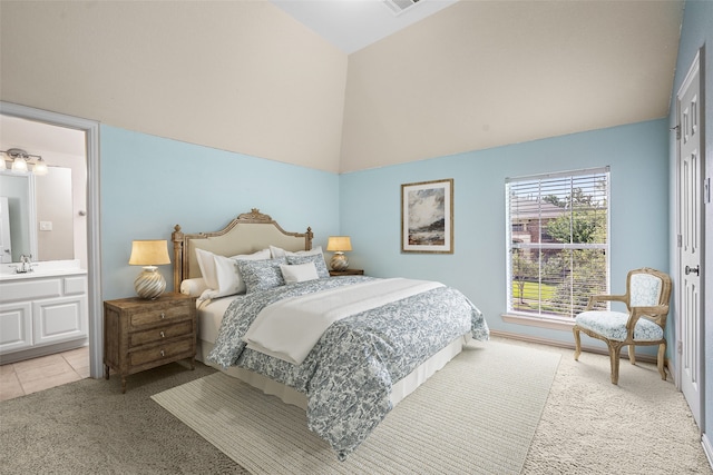 bedroom featuring a towering ceiling, connected bathroom, light colored carpet, and sink